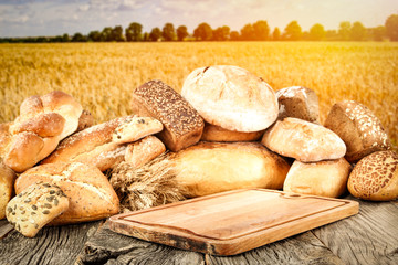 Fresh fragrant bread on a wooden table in a beautiful golden cereal     