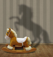 The rocking toy horse casts the strange shadow on a wall of the room.