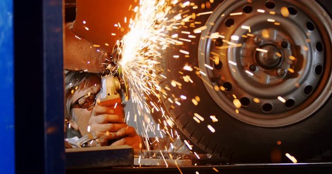 Male mechanic using grinder machine 4k