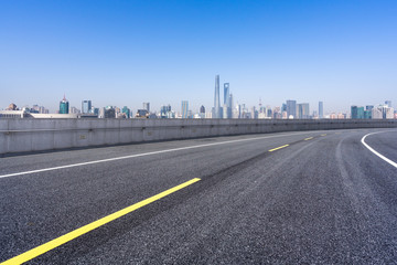 empty asphalt road with city skyline