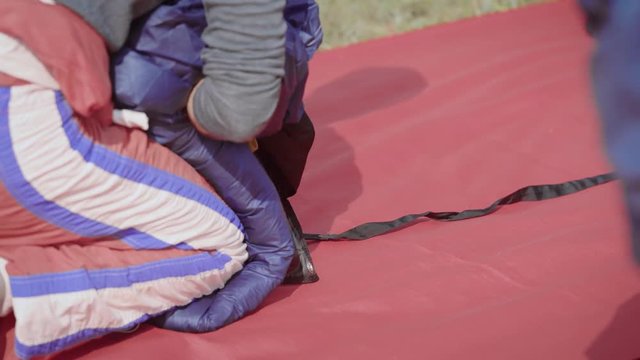 An adult man folds his parachute