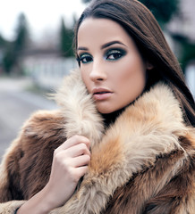 Young woman wearing fur coat outdoors