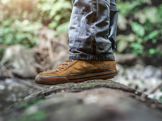 Close up Shoes of traveler walking in the forest. Lifestyle hiking concept.