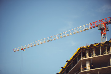 tower crane at the construction site against the sky, unfinished building