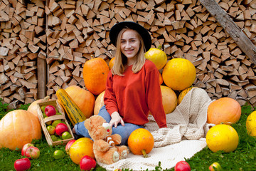 The girl sits next near for pumpkins. Thanksgiving, Halloween