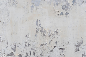 Grunge white metal wall with peeling paint, close-up background photo texture