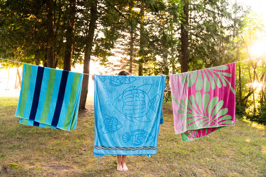 A girl hanging towels on clothes line