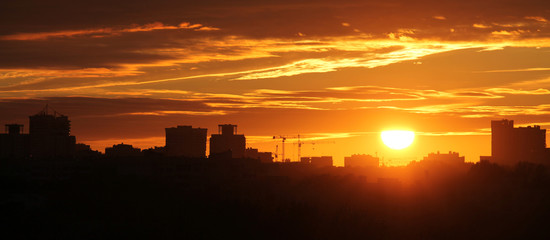 Panoramic view of cityscape with silhouette of city skyline against setting sun. Minsk, Belarus