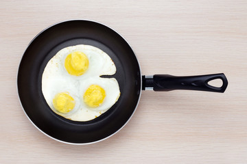 Three chicken eggs fried in a frying pan