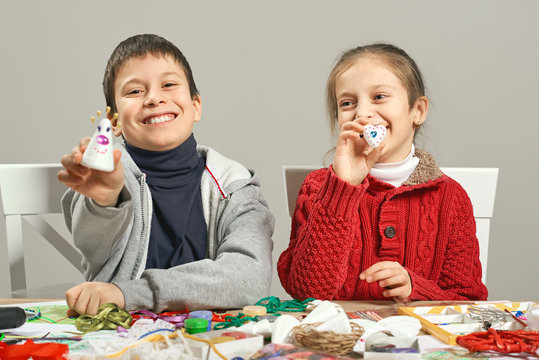 Childrens making decorations for new year holiday. Painting watercolors. Top view. Artwork workplace with creative accessories.