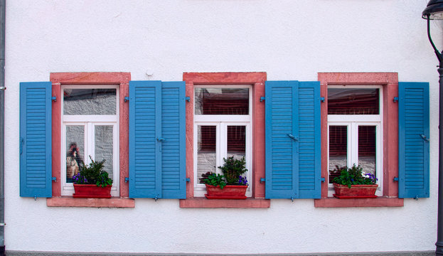Three windows with blue shutters