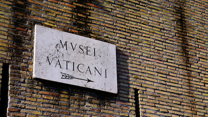 written Vatican museums in Italian on marble plaque above the vativane walls, seen from below
