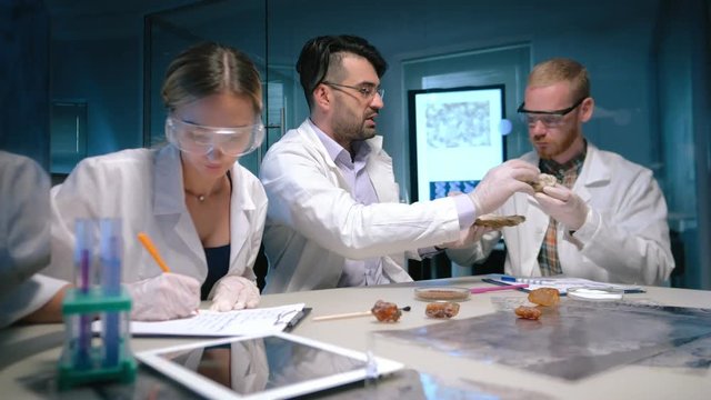 Professor and researchers investigating minerals