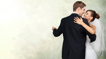 Happy just married young couple dancing on blurred background