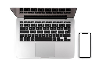 Obraz na płótnie Canvas Top view of modern laptop with blank screen smartphone
