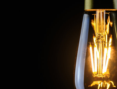 Close-up photo of light bulb on black background.