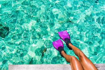 Beach vacation travel snorkel woman legs swimming in turquoise blue ocean tropical holiday texture background with fish in the sea. Swim fun in luxury resort destination. © Maridav