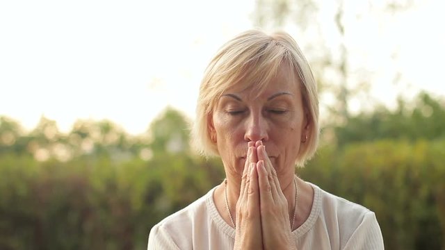 Elderly woman praying or meditating, close-up