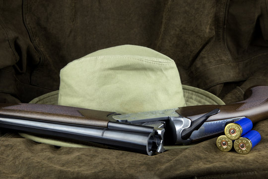 Shotgun and Cartridges with Hat on Outdoor Coat