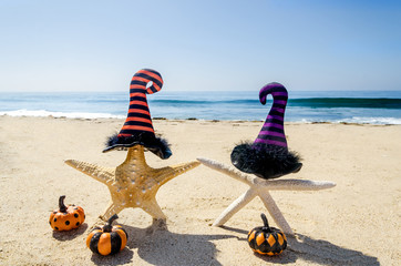 Obraz premium Halloween background on the beach with starfishes in witch's hats