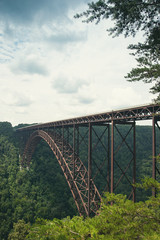 A view of the steel metal arch bridge over the New River Gorge in Fayetteville, West Virginia.  The bridge is the longest steel span in the western hemisphere.  Repeating lines.  Vertical image.