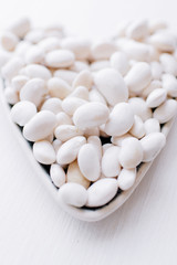 Art heart from a string bean on a wooden light background symbolizing a healthy diet