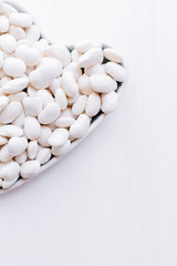 Art heart from a string bean on a wooden light background symbolizing a healthy diet