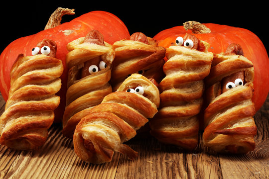 Mummy sausages scary halloween party food decoration wrapped in dough.