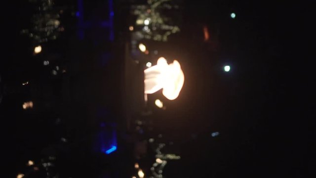 Vertical video closeup of flame of burning torch outdoors at night