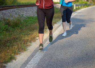 women jogging along a country road