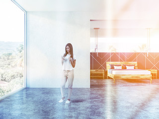 Fototapeta na wymiar Woman with phone in white panoramic bedroom