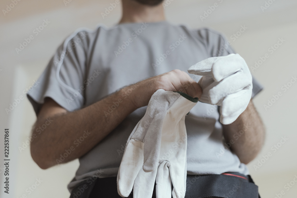 Wall mural Professional repairman wearing protective gloves