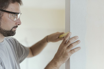 Man measuring a wall using a folding ruler