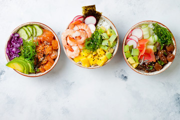 Hawaiian salmon, tuna and shrimp poke bowls with seaweed, avocado, mango, pickled ginger, sesame...