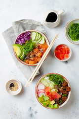Hawaiian salmon, tuna poke bowls with seaweed, avocado,  pickled ginger, sesame seeds. Top view, overhead, flat lay