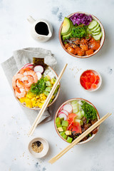Hawaiian salmon, tuna and shrimp poke bowls with seaweed, avocado, mango, pickled ginger, sesame seeds. Top view, overhead, flat lay