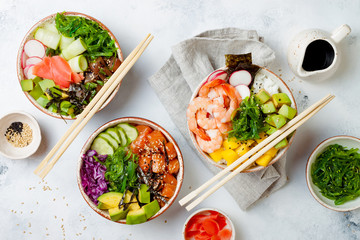 Hawaiian salmon, tuna and shrimp poke bowls with seaweed, avocado, mango, pickled ginger, sesame...