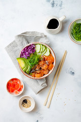 Hawaiian salmon poke bowl with seaweed, avocado, cucumber, cabbage, sesame seeds. Top view,...