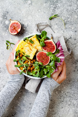 Vegan, detox Buddha bowl recipe with turmeric roasted tofu, figs, chickpeas and greens. Top view,...