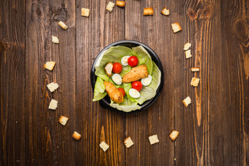 Caesar salad with chicken, cherry tomatoes and quail eggs on a plate