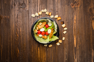Caesar salad with chicken, cherry tomatoes and quail eggs on a plate