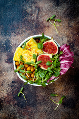 Vegan, detox Buddha bowl recipe with turmeric roasted tofu, figs, chickpeas and greens. Top view, flat lay, copy space