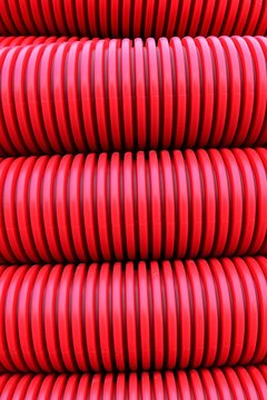 Texture of detail of red flexible cable protection tube coiled in one roll
