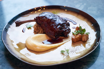 Duck confit with Quinoa puree, celery, apple with cinnamon sauce served on plate. Exclusive restaurant meals