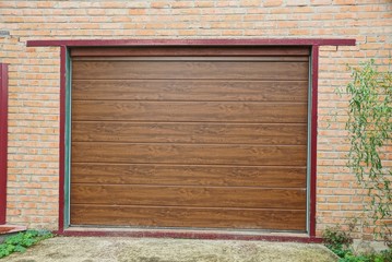 brown plastic gate on the brick wall of the garage