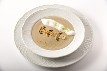 Mushroom cream soup with herbs and spices on a white background