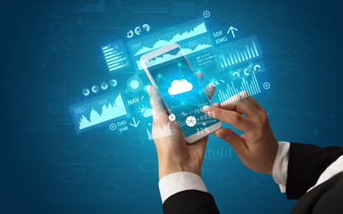 Female hand using smartphone with financial tracking concept illustrated by graphs and symbols