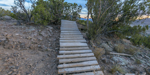Fototapeta premium Wooden trail on rocky hill during sunset