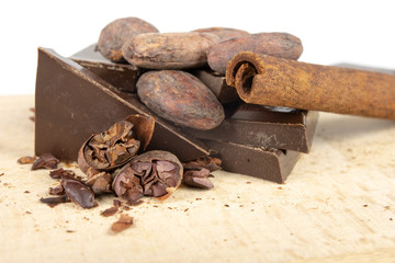 Tasty dark chocolate and cocoa beans on a white table. Sweets used to prepare desserts in the kitchen.