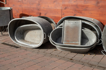 Old metal bathtub based on a wooden wall. Accessories for personal hygiene. Season of the autumn.